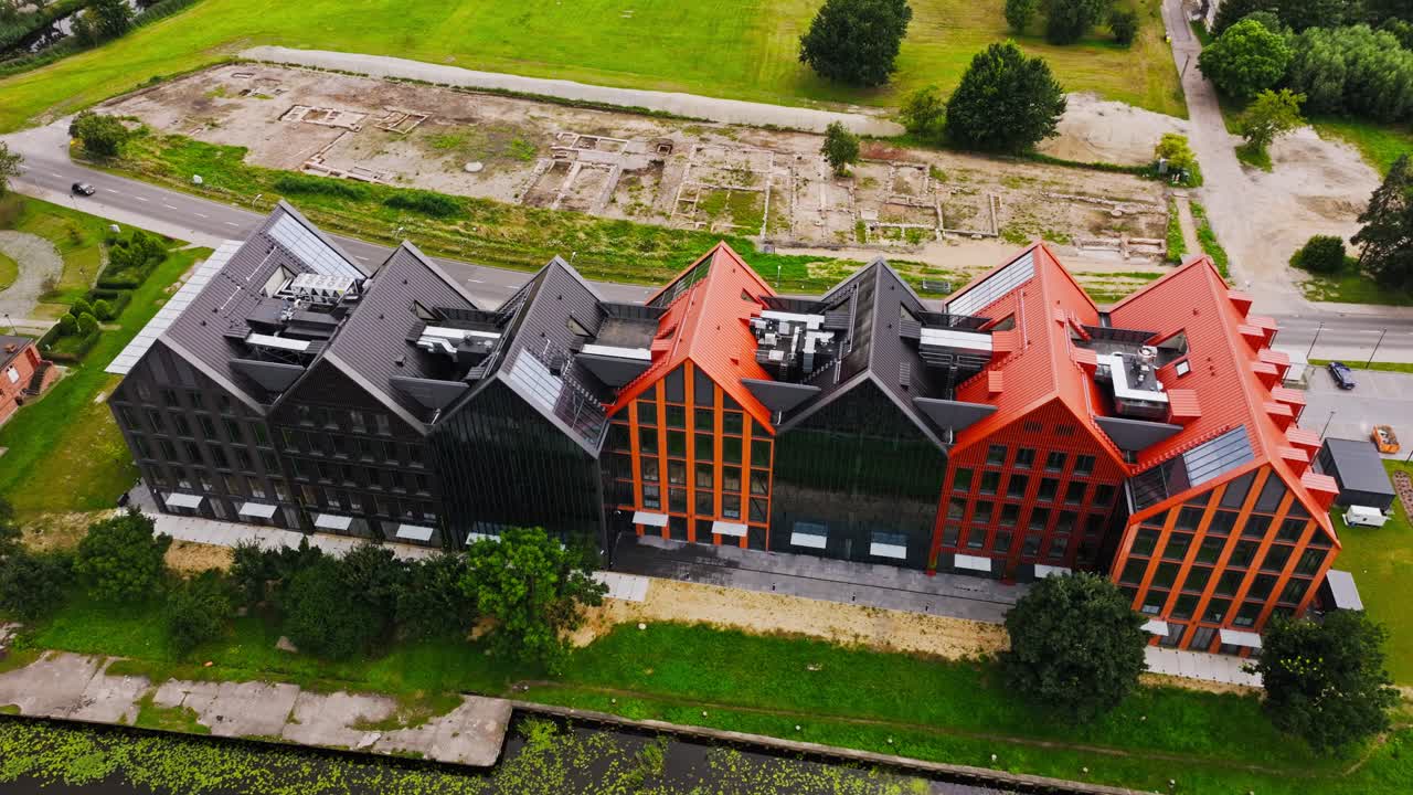 Cinematic drone orbit showing riverside modern buildings in Elbląg Poland