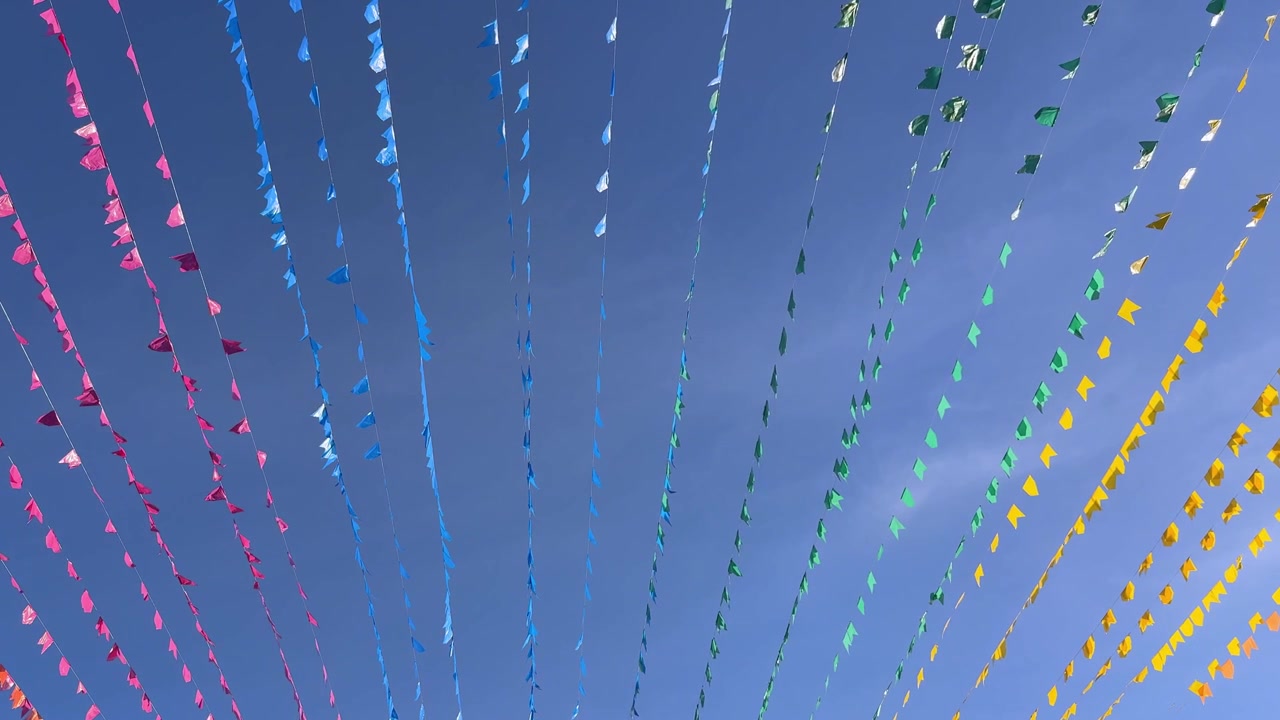 Bandierine colorate che ondeggiano contro un cielo azzurro limpido