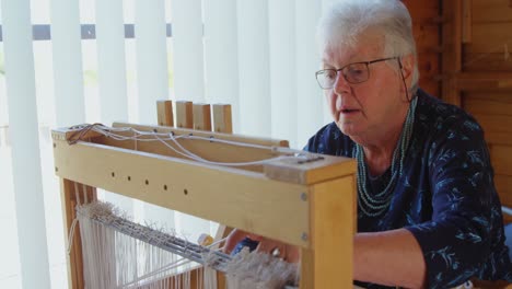 Senior-woman-operating-weaving-machine-4K-4k