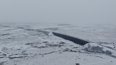 Establecimiento-De-Una-Toma-Aérea-Con-Drones-Del-Viaducto-Ribblehead-En-Un-Día-Nevado-Y-Sombrío-En-Los-Valles-De-Yorkshire-En-El-Invierno-Del-Reino-Unido