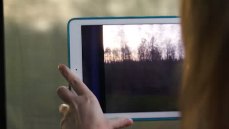 Frau-Mit-Block-Im-Zug-Macht-Ein-Video-Einer-Vorbeifahrenden-Landschaft