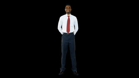 Businessman-standing-and-smiling-against-black-background