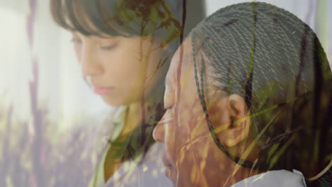 Two-female-health-workers-against-tall-grass-moving-in-background