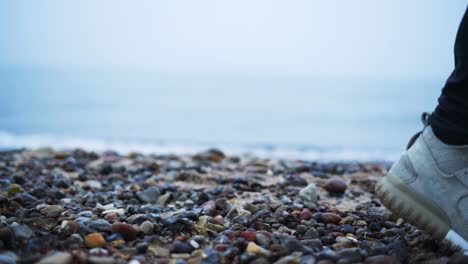 walking at the cold winter beach, shoe close up in slow motion