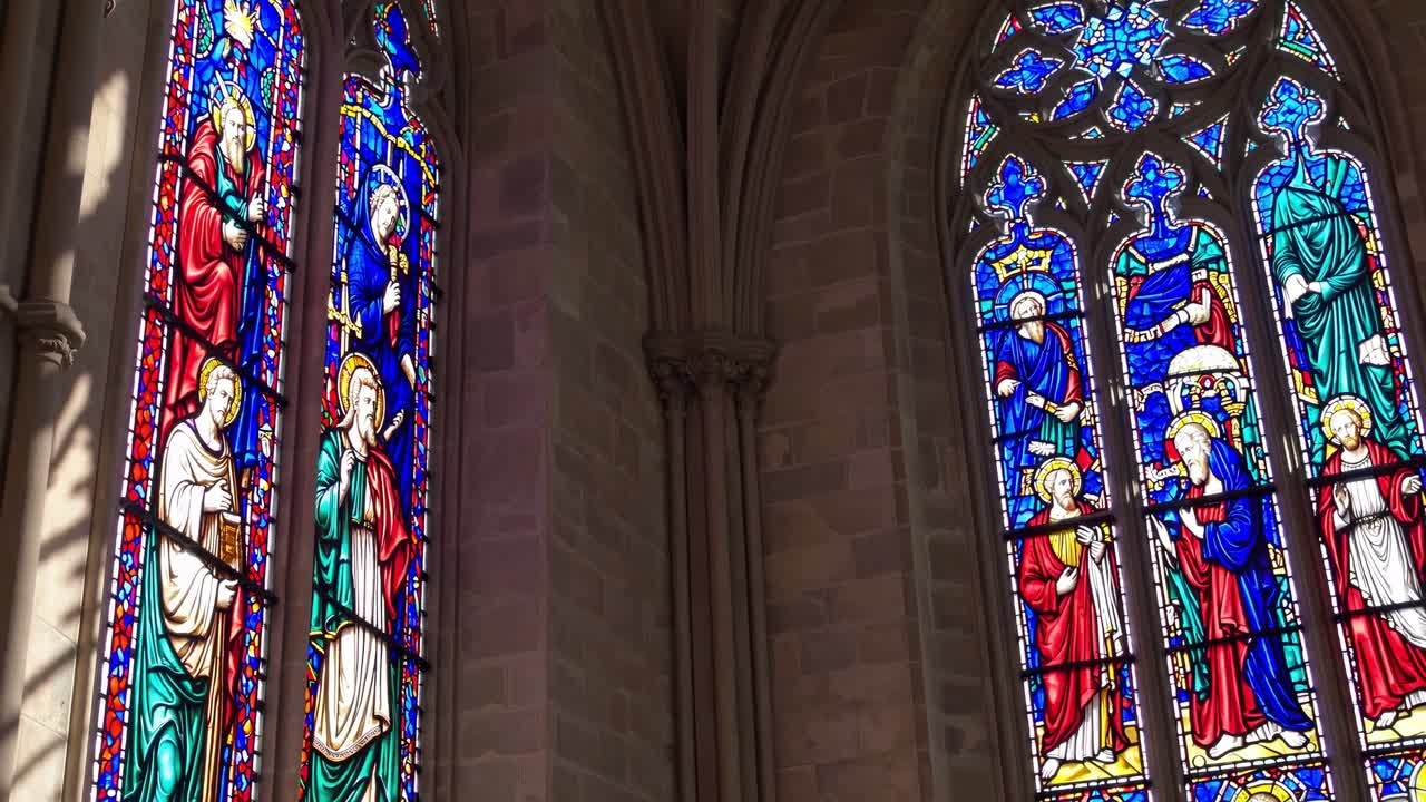 Vibrant stained glass windows depicting religious figures and intricate designs, showcasing the beauty and artistry of sacred architecture in a serene setting