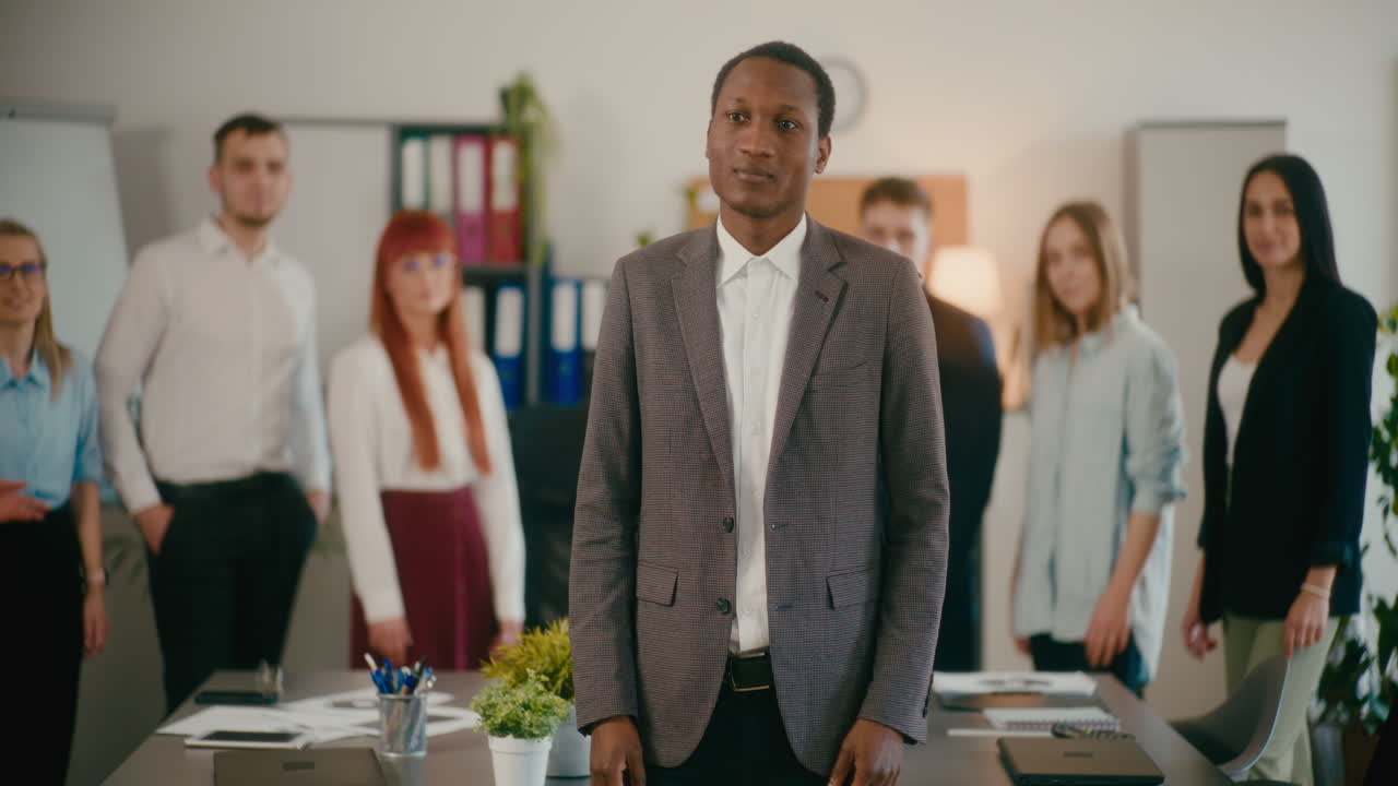 gerente confiado con empleados aplaudiendo en el fondo.