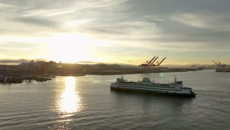 el sol del amanecer se refleja en la bahía de elliot mientras un ferry se acerca a la costa de seattle.