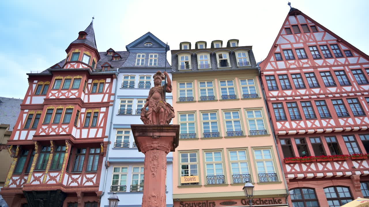 Una statua situata nel Römerberg, Francoforte, Germania. Edifici a graticcio sullo sfondo