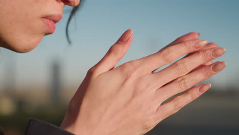 toma de primer plano de las manos frotándose suavemente entre sí, transmitiendo un sutil gesto de profunda contemplación y dolor. la cabeza de la persona es parcialmente visible, insinuando un momento de tristeza