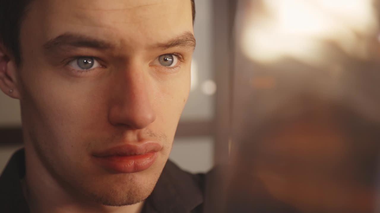 자신의 방 안에 있는 네거티브 현상 사진 필름 스트립을 자세히 보고 있는 젊은 사진사