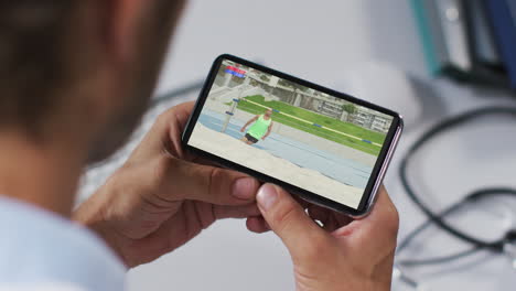 composite of male doctor watching athletics high jump event on smartphone