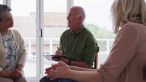 dos parejas de ancianos diversos sentados en círculo teniendo una conversación de terapia en casa