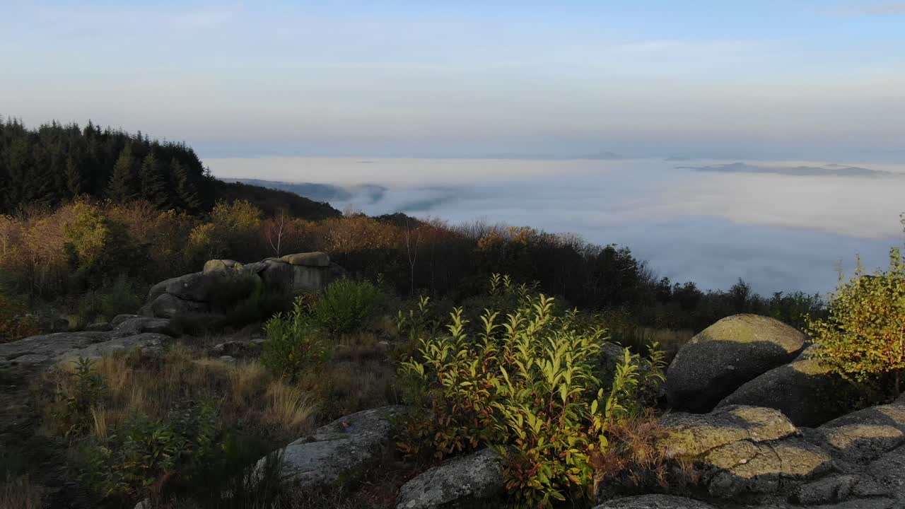 drone volando a baja altura sobre las rocas de uchon con nubes sobre el paisaje de fondo