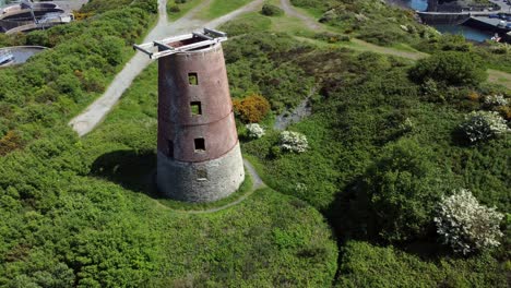 amlwch port red brick disused abandoned windmill aerial view north anglesey wales flyover birdseye shot