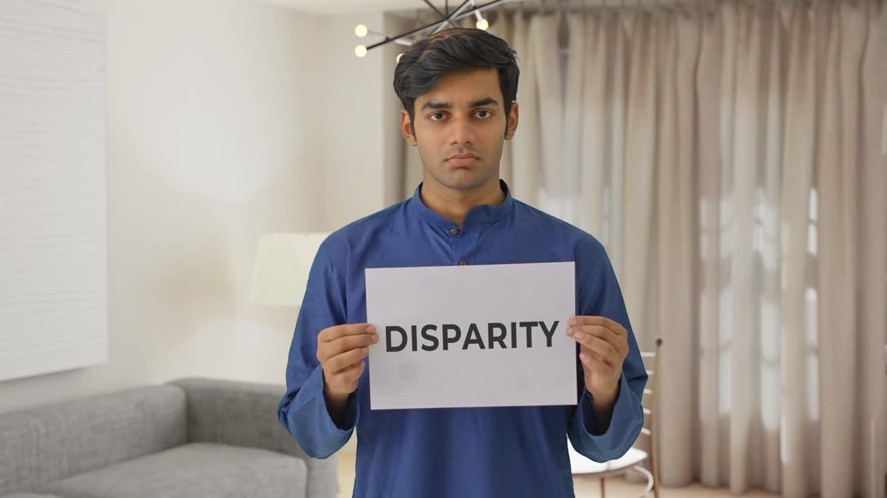 Sad Indian boy holding DISPARITY banner