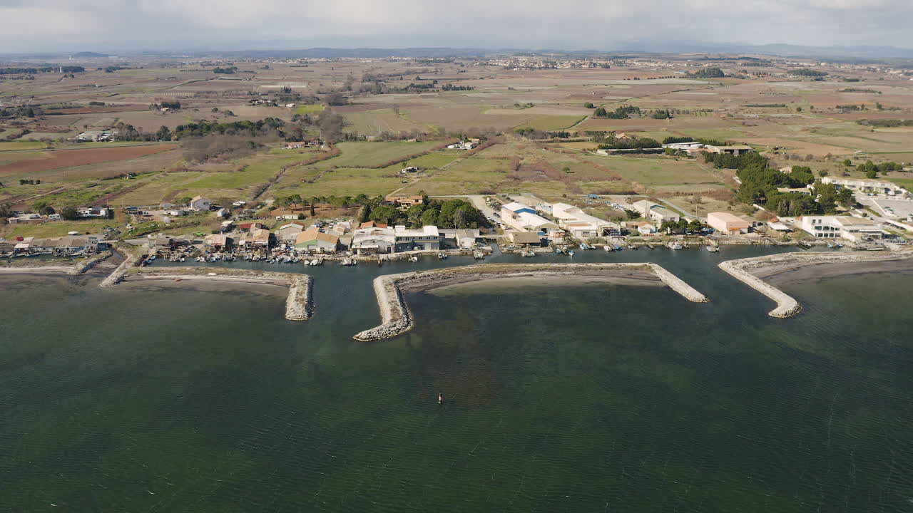 pequeño puerto pesquero de mazets drone aéreo disparado con campos agrícolas detrás