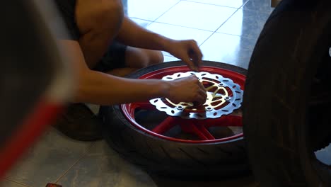 close-up footage of mechanic working on disc brake installation for motorcycle