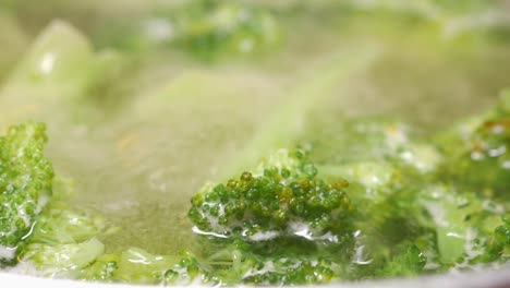 close up of broccoli florets boiling in water