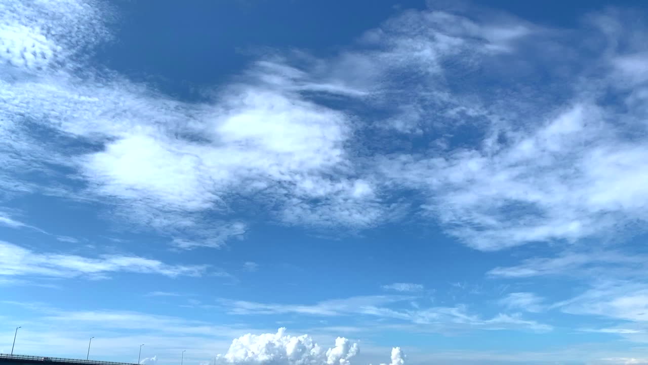 Amakusa Japan timelapse pan down to boats in seafront harbour under fast clouds