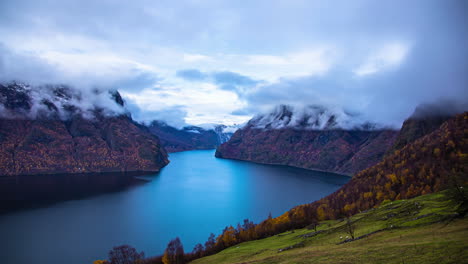 Lapso-De-Tiempo---Vista-Majestuosa-Del-Fiordo-Desde-Un-Punto-De-Vista-Alto,-Niebla-Arremolinada-Alrededor-De-Picos-Montañosos-Nevados,-Flam,-Noruega