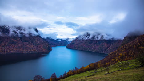 time lapse - majestic fjord view from high vantage point, swirling mist around snow capped mountain peaks, flam, norway
