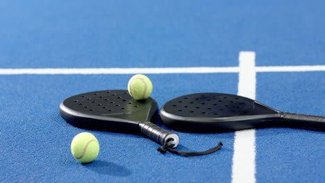 padel rackets and balls on indoor court, ready for exciting match, copy space