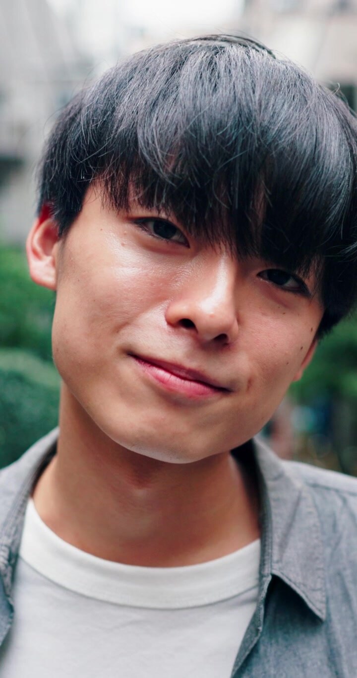 Ritratto di un giovane uomo asiatico che sorride all'aperto