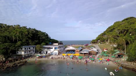 aerial establishing shot of the praia da sepultura and the sea on both sides of a hill