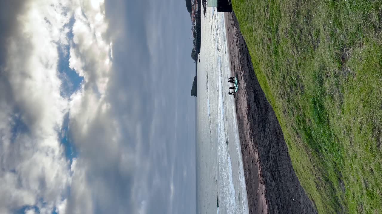 해변에 있는 개인들이 낮의 빛 아래 물 에서 여가 활동에 몰두하는 것을 보여주는 수직 비디오, 여가와 휴식의 본질을 구현합니다.