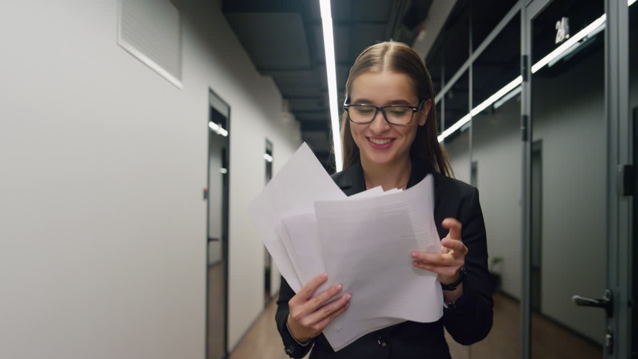 el gerente alegre comprueba los documentos que van por el pasillo. agente de ventas feliz mira el contrato