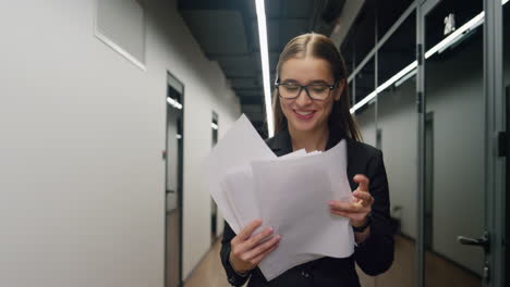 Joyful-manager-check-documents-going-corridor.-Happy-sales-agent-look-contract