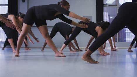 grupo multiétnico de bailarines modernos en forma masculinos y femeninos practicando una rutina de baile