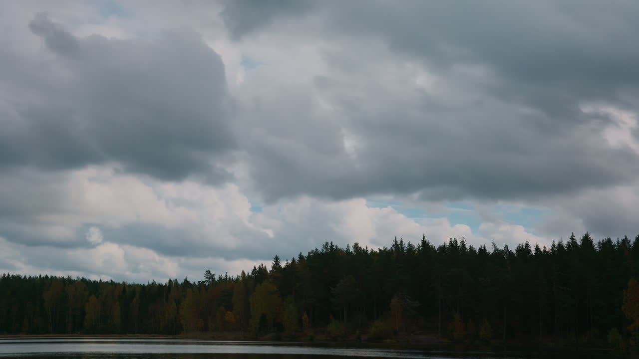 Time lapse shot of the clouds moving over a lake and the forest outside Oslo, Norway