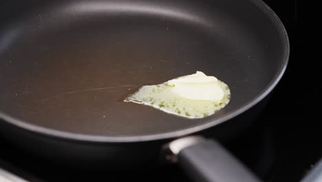 butter melting and bubbling in hot frying pan before adding ingredients for cooking