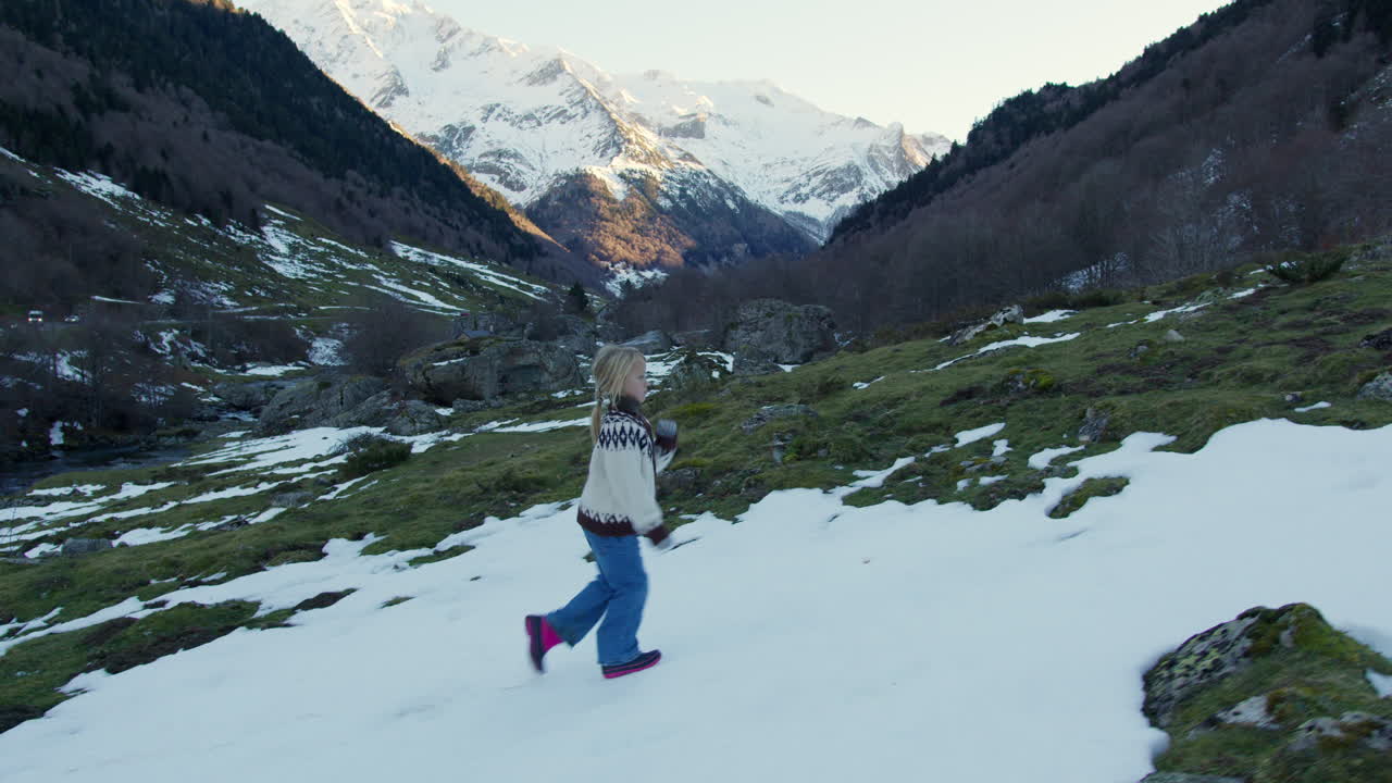 Child Walking in Snowy Mountains