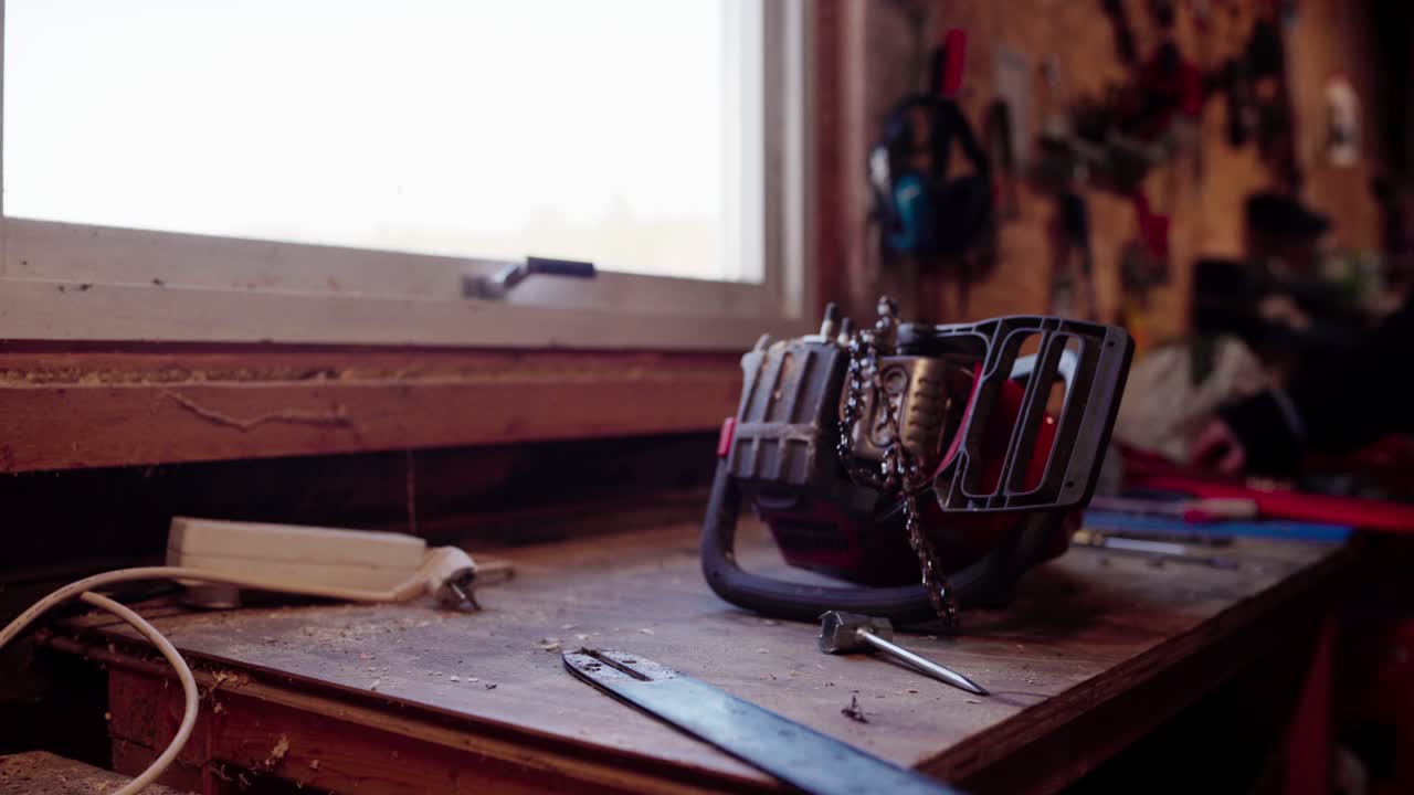 el hombre se está preparando para arreglar su motosierra - de cerca