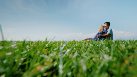 multi-ethnic couple resting on the green grass admiring the beautiful nature