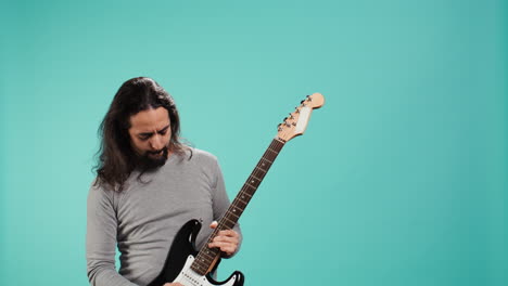 man with long hair performing metal songs on guitar