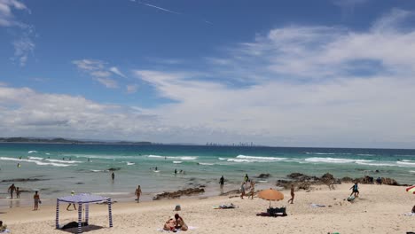 people enjoying a sunny beach with various activities