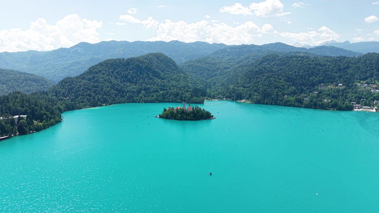 Lago di Bled, Slovenia. Ripresa Drone di Acqua Turchese Alpina e Isola Sotto le Colline delle Alpi Giulie