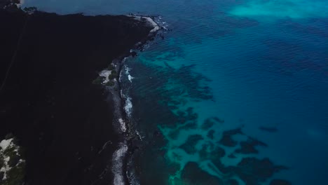 the black sand complimented by the turquoise water of hawaii