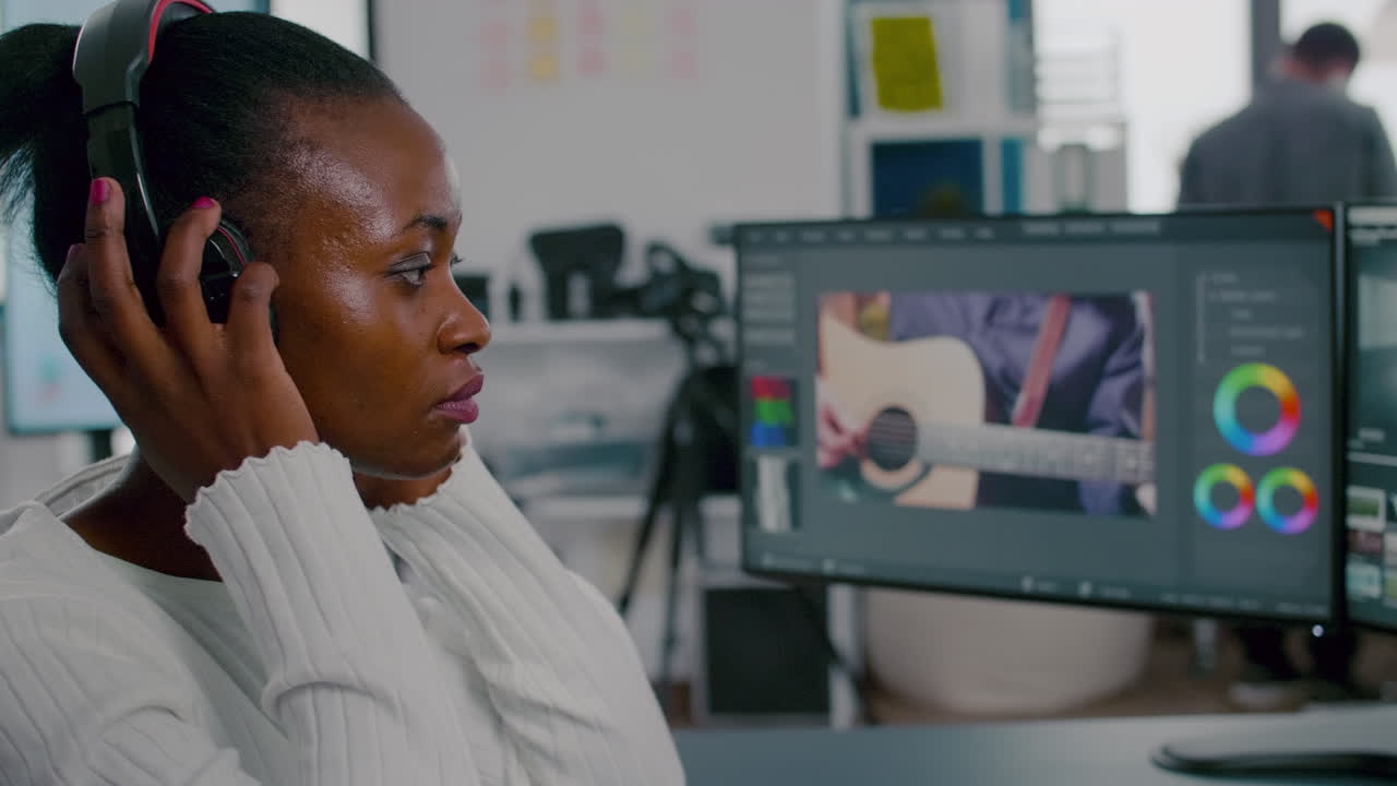 헤드폰을 들고 비디오 영상을 편집하는 아프리카 여성 비디오 촬영자
