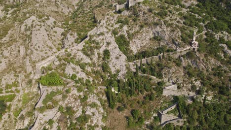 Aerial-establishing-shot-of-Kotor-Fortress-Walls-along-rocky-Mountain,-Montenegro