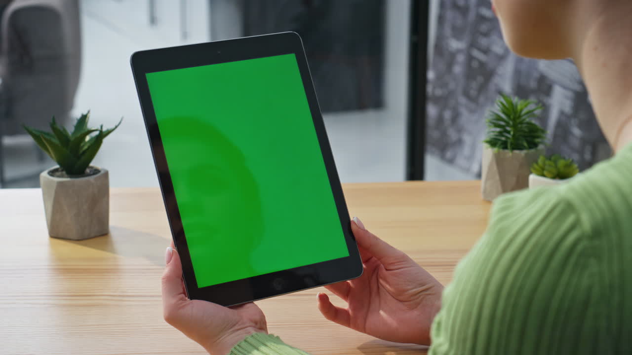 Businesswoman holding horizontal mockup tablet at corporate workplace closeup