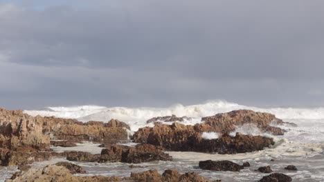 pan left as powerful shore break surges onto rocky south african coast