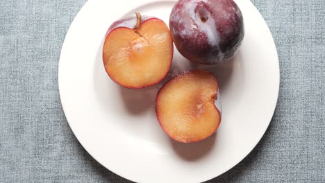 fruta de ciruela roja fresca en rodajas en una mesa de madera foto de alta calidad