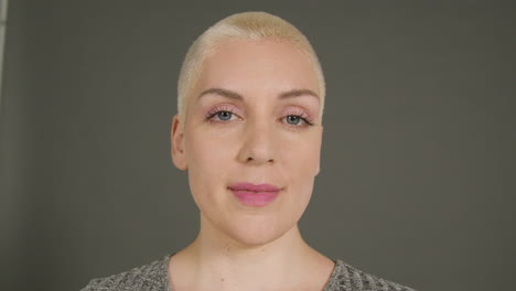 female model poses for camera in front of grey backdrop 01