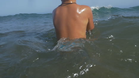 con un niño nadando con la pelota en el mar ondulado