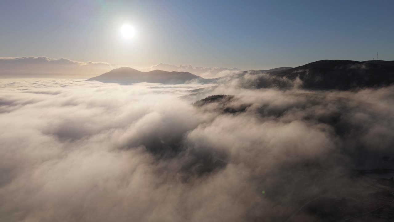 아일랜드 던달크의 추운 아침에 산맥을 고 있는 구름 위에 밝은 빛.