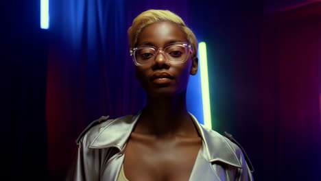 stylish woman with blonde hair and glasses in neon lights